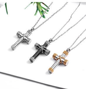 Detailed view of silver, black and gold cross pendant necklaces on a clean surface