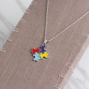 Detail of four-piece colorful puzzle heart necklace for best friends on display