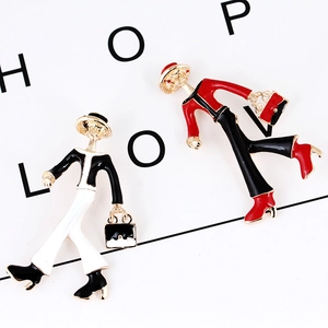 Close-up of enamel modern lady brooches with red and black dresses on a book