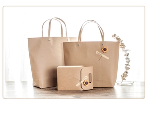 Close-up of vintage brown kraft paper gift bags and box with dried flowers