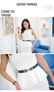 Detail of slim black elastic waist belt with gold interlocking buckle on white dress
