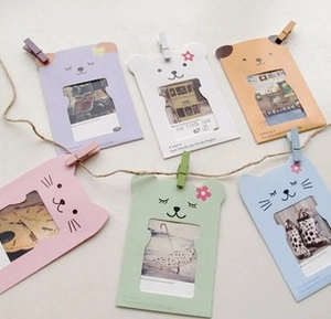 Detail of macaron animal paper frames with colored wooden clips and jute rope for photo wall