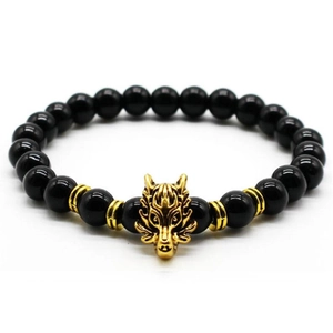 Macro shot of men's lava stone bracelet featuring a golden dragon charm on white background