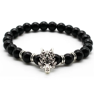 Detailed view of silver dragon charm bead on a black volcanic stone stretch bracelet