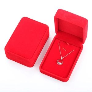 Detailed view of red velvet necklace gift box with elegant silver circular pendant inside