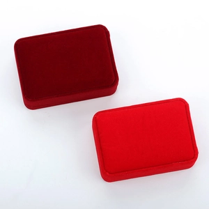 Detail view of premium velvet jewelry boxes in dark and bright red for rings and necklaces
