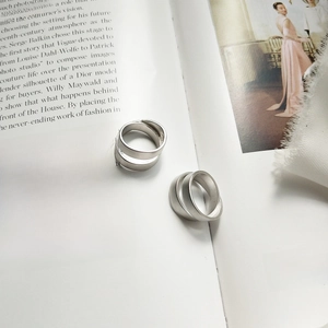 Close-up of minimalist silver double-layer rings with matte brushed finish on a magazine