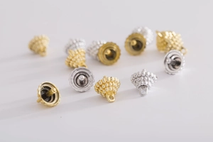Macro shot of gold and silver textured metal ornament caps with hanging loops