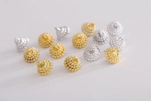 Close-up of gold and silver granular metal textured round button caps for Christmas ornaments