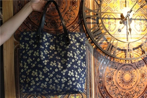 Détail du sac en toile bleu marine à motif cerisier et poignées en cuir noir