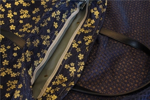 Détail du sac en toile bleu marine avec fermeture éclair argentée et imprimé fleurs de cerisier
