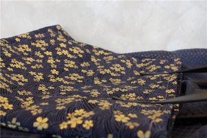 Gros plan sur un sac cabas en toile bleu marine aux motifs dorés sakura et vagues
