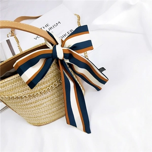 Straw handbag with blue and brown striped silk scarf ribbon and elegant gold chain detail