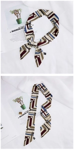 Detailed view of 100% polyester twilly silk scarf with classic belt and chain pattern