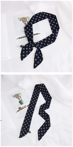 Detailed view of a dark blue polka dot silk scarf tied on a French magazine background