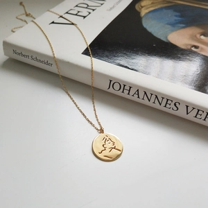 Elegant 925 sterling silver gold necklace featuring an abstract face profile pendant on a book