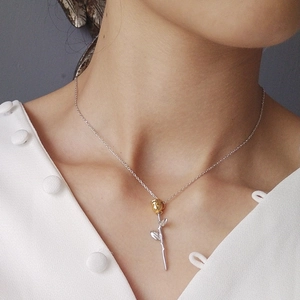 Elegant 925 silver necklace featuring a gold rose pendant on a woman wearing white