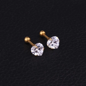 Sparkling zircon heart stud earrings with gold plating on black leather background
