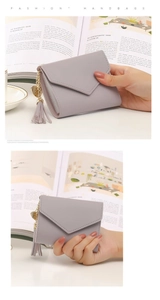Gray short wallet for women featuring a heart pendant, tassel, and PU leather texture