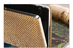 Close-up of luxury gold rhinestone evening clutch with side view and metal chain