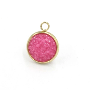 Macro view of a round gold stainless steel charm with pink resin druzy crystal inlay