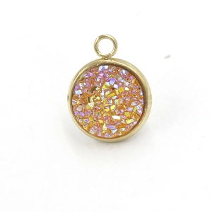 Macro view of a gold circular resin pendant featuring colorful iridescent stone inlay