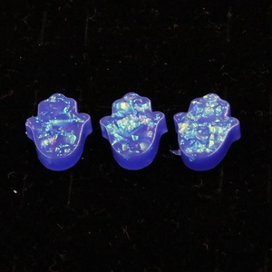 Close-up of three blue synthetic opal Hamsa hand charms for DIY jewelry making