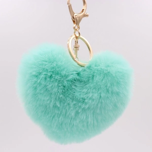 Detail of mint green heart plush keychain with soft faux fur and gold metal hardware