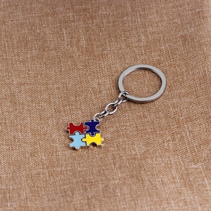 Close-up of four-color puzzle pendant necklace on brown linen background texture