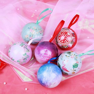 Close-up of decorative round tin cases with diverse patterns on a pink mesh background