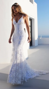 Lace wedding dress detail showing white floral embroidery and deep V-neck mermaid silhouette