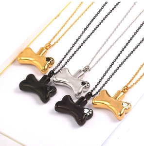 Detail of dog bone cremation pendants in gold, silver, and black stainless steel