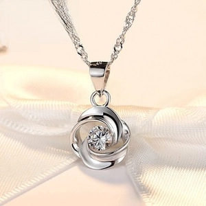 Macro shot of S925 sterling silver hollow rose pendant with sparkling white gemstone center