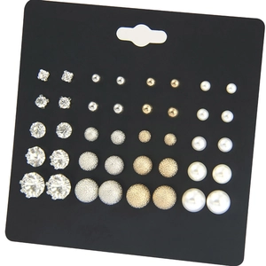 Macro detail of a 20-pair earring set featuring silver zircons and white pearls on white card