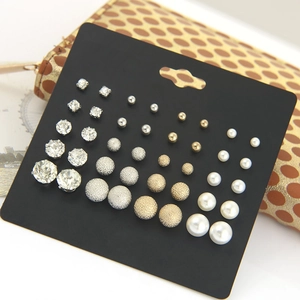 Macro detail of 12-pair earring set featuring faux pearls, rhinestones and metal studs