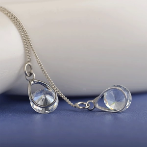 Détail macro de boucles d'oreilles pendantes argentées avec cristaux de zircone