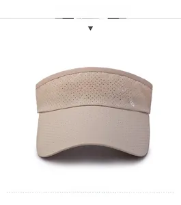Detail of beige sun visor featuring breathable mesh fabric and white sports embroidery