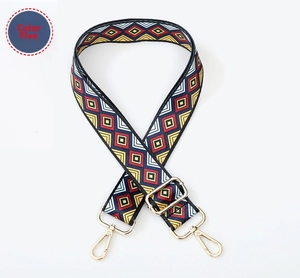 Close-up of geometric diamond pattern on wide woven bag strap with golden buckles