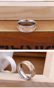Detailed macro of two-tone stainless steel ring with golden geometric pyramid relief pattern