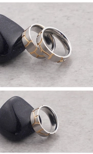 Detail of titanium steel ring with silver brushed finish and gold grooved inlay detail