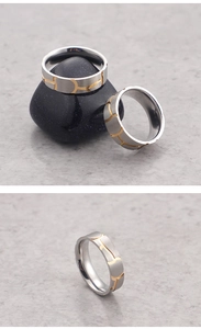 Close-up of titanium steel ring with silver brushed finish and golden curved inlay