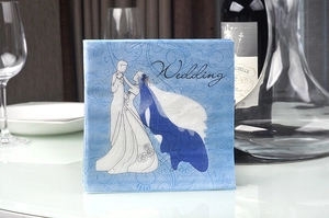 Detailed shot of blue wedding napkins with white silhouettes and texture on a table