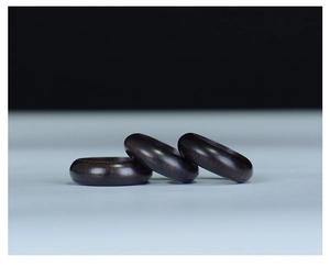 Detailed view of three polished dark purple sandalwood rings with natural wood grain