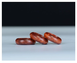 Macro shot of three polished blood sandalwood rings with natural wooden grain