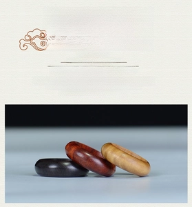 Detailed view of three polished wood rings in rosewood, ebony and sandalwood finishes