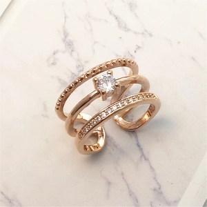 Detail of rose gold triple-layer open ring featuring sparkling pave cubic zirconia accents
