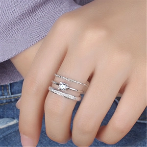 Close-up of three layered silver rings with sparkling cubic zirconia on a female finger