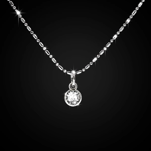 Macro shot of silver chain necklace with a brilliant round clear gemstone pendant