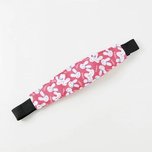 Close-up of pink stroller head support strap with cute white cartoon rabbit pattern
