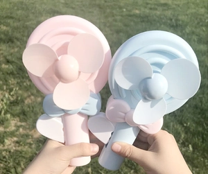 Close-up of pink and blue lollipop-shaped handheld manual fans held outdoors